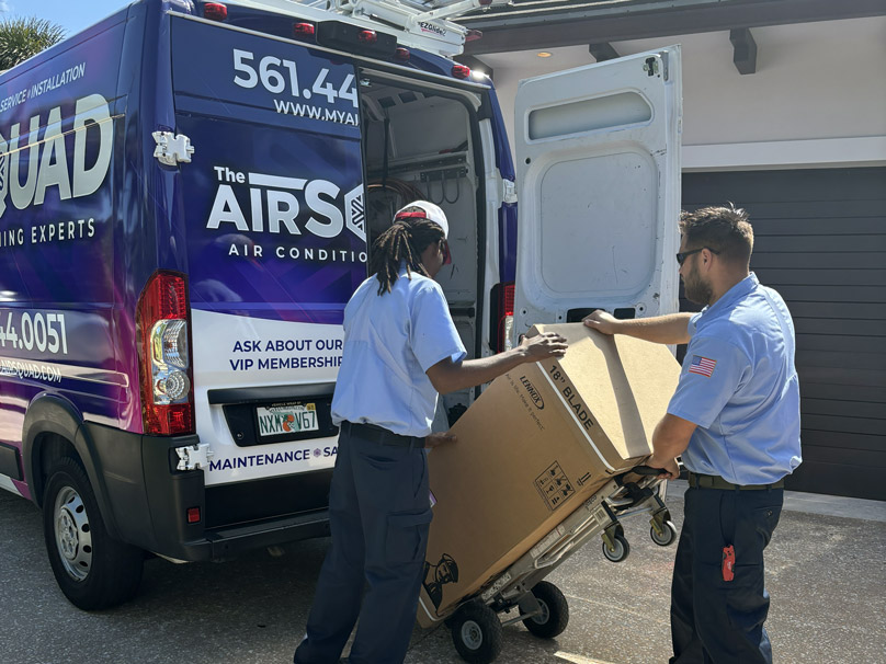 The Air Squad team moving HVAC units out of work van