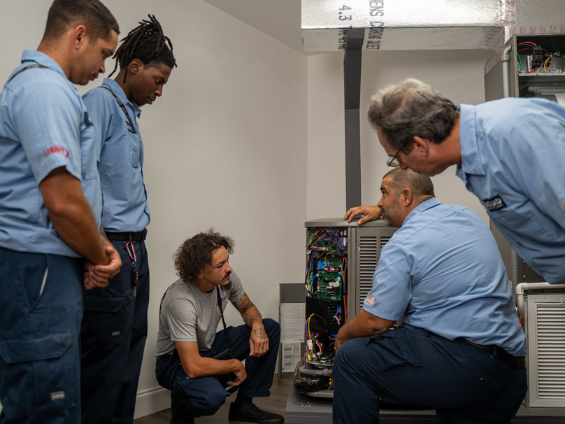 Air Squid HVAC team looking at air conditioner unit